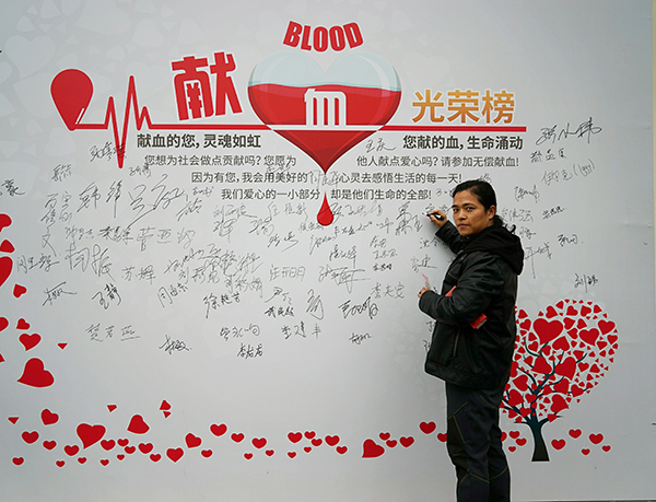 图说:王晋在献血光荣榜上签名爱运动更乐于献爱心今年40岁的王晋居住