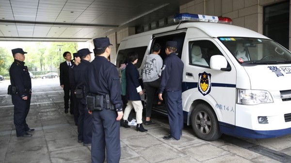 图说:法警押送被拘留被执行人上警车宝山区法院供图